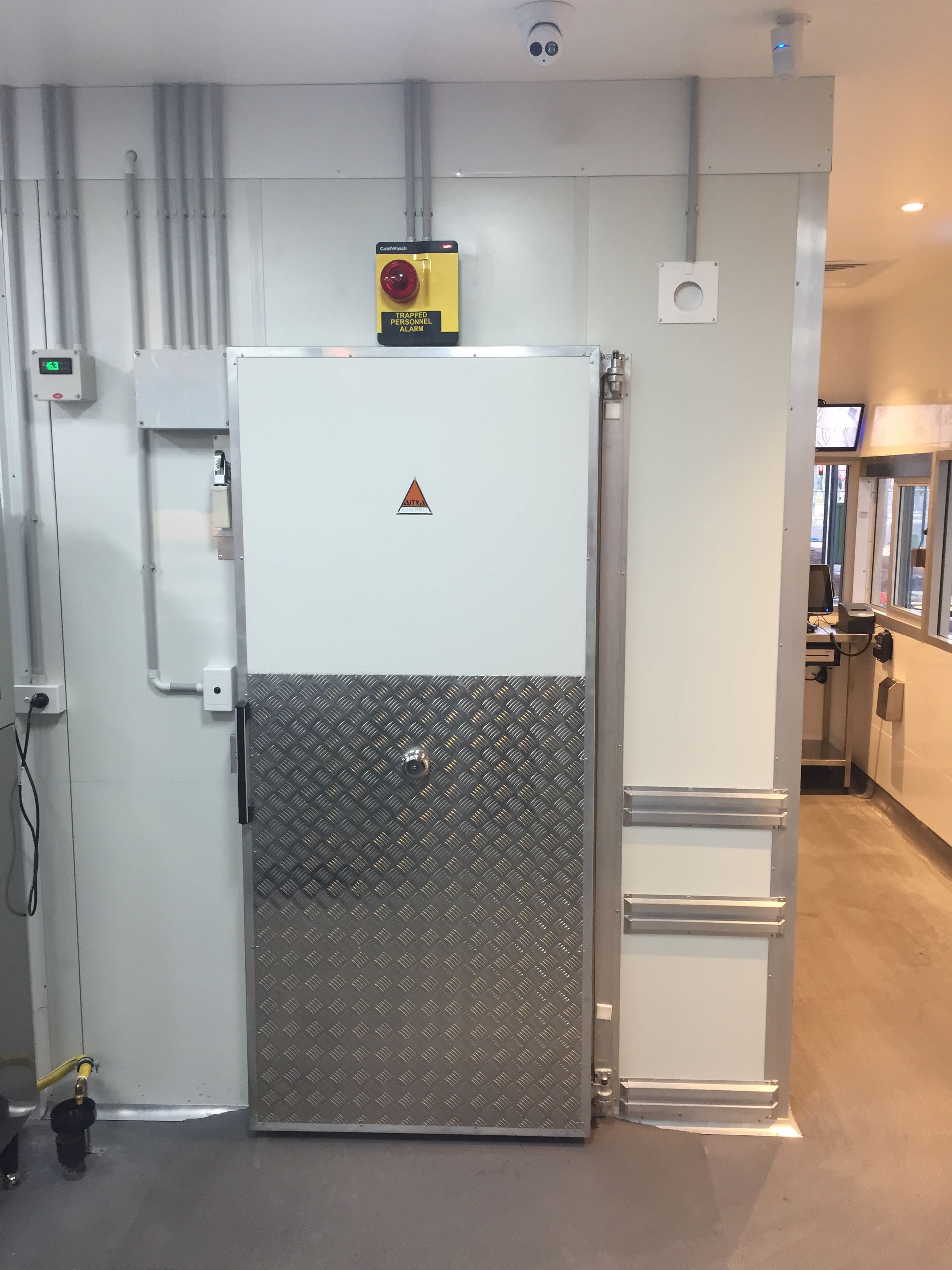 A stainless steel door with a yellow triangle on it