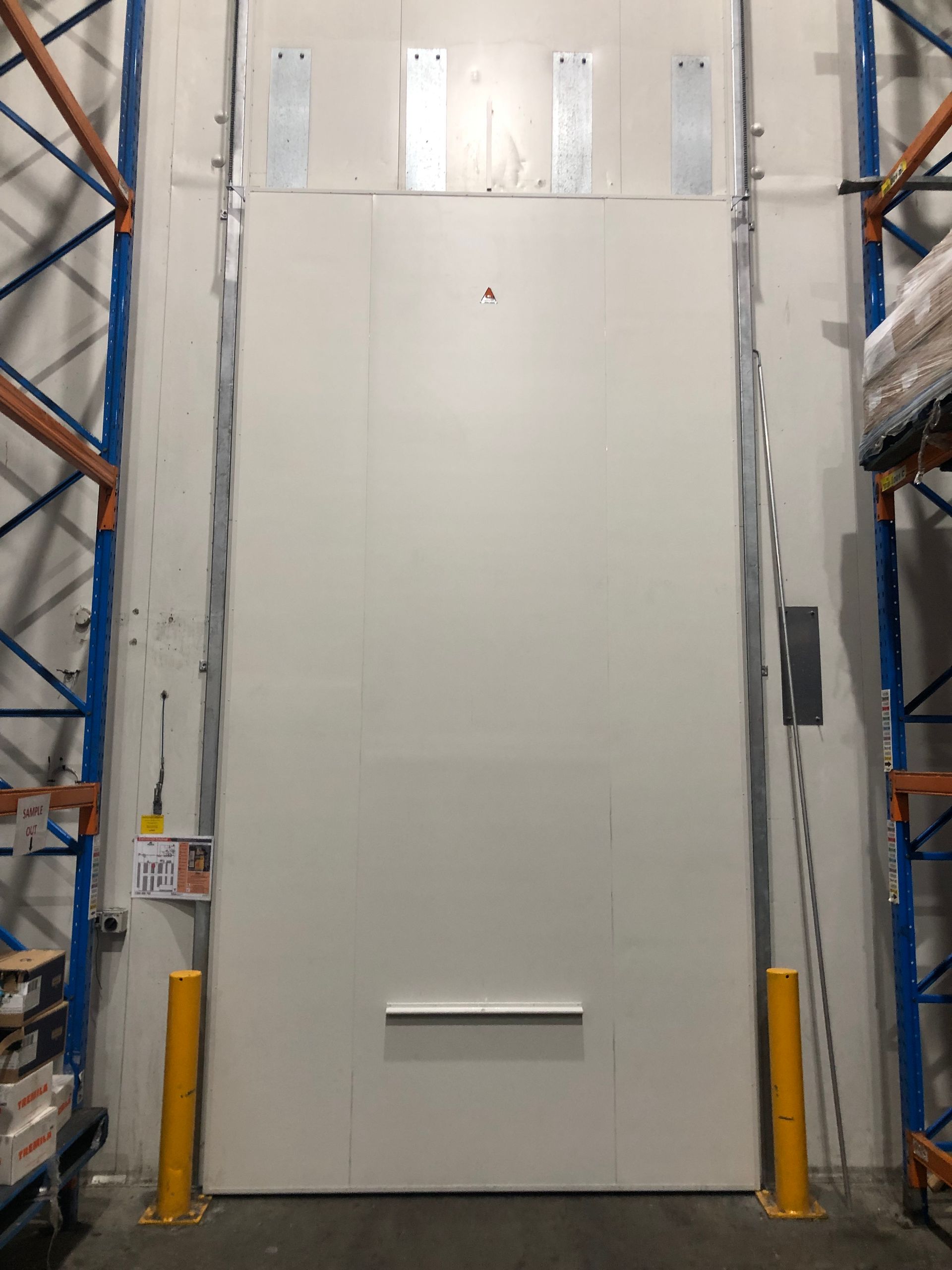 A large white door is open in a warehouse