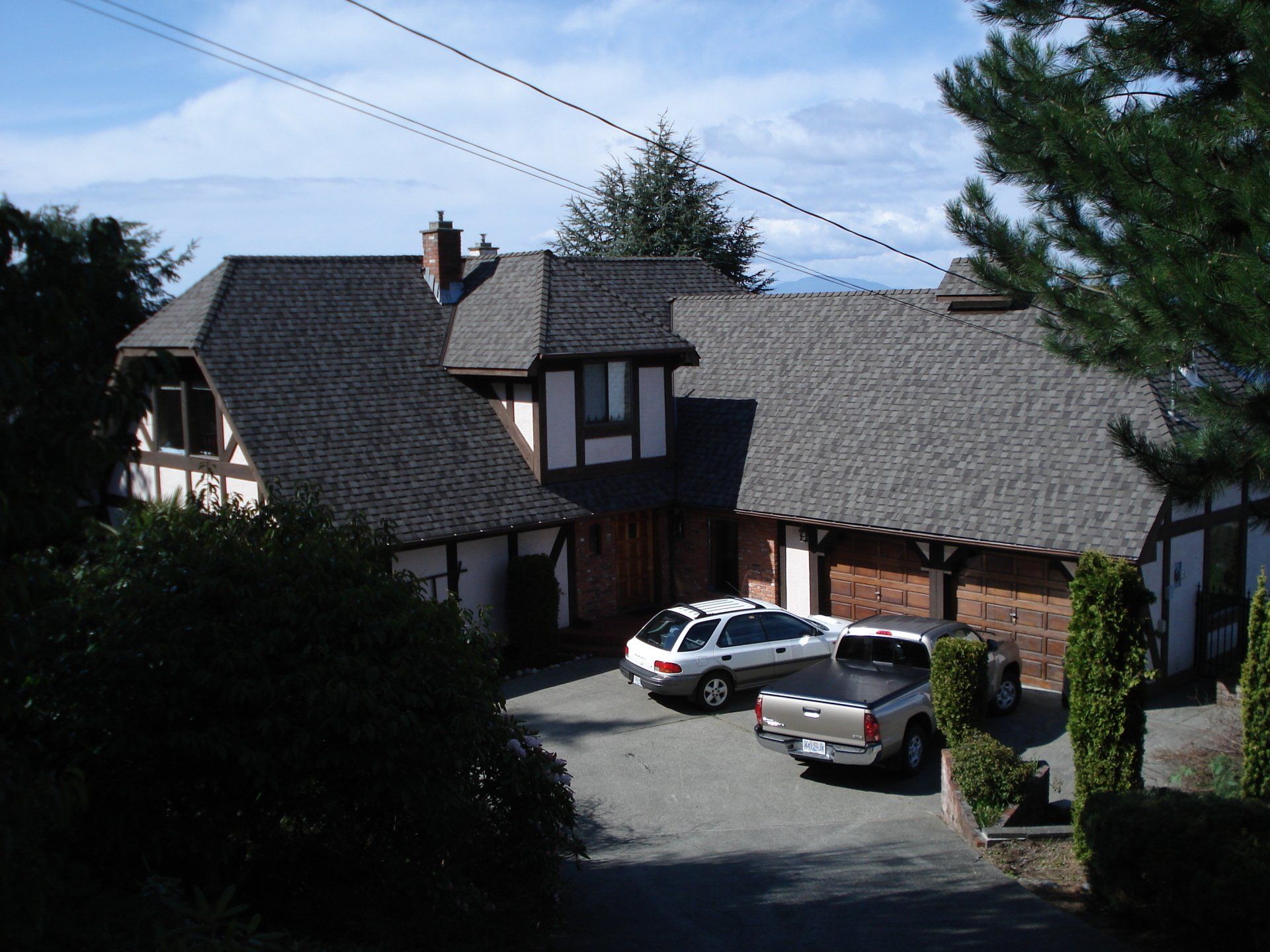 A white truck is parked in front of a large house