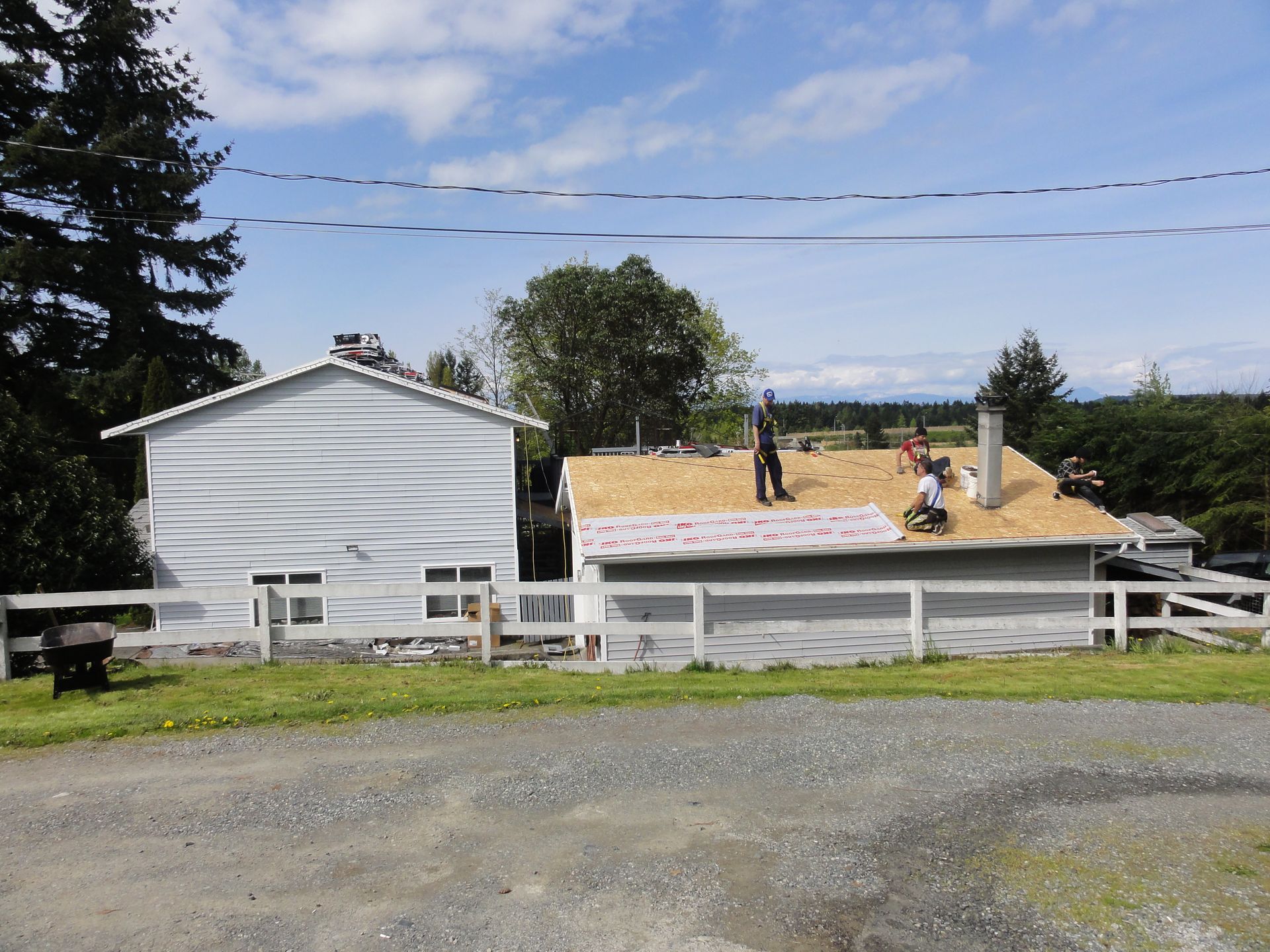 A group of people are working on the roof of a house