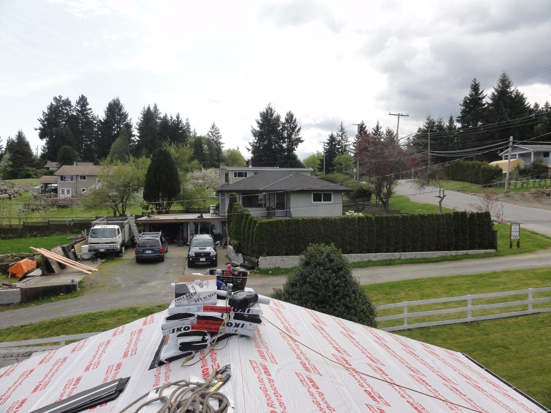 A roof with a lot of tools on it and a house in the background