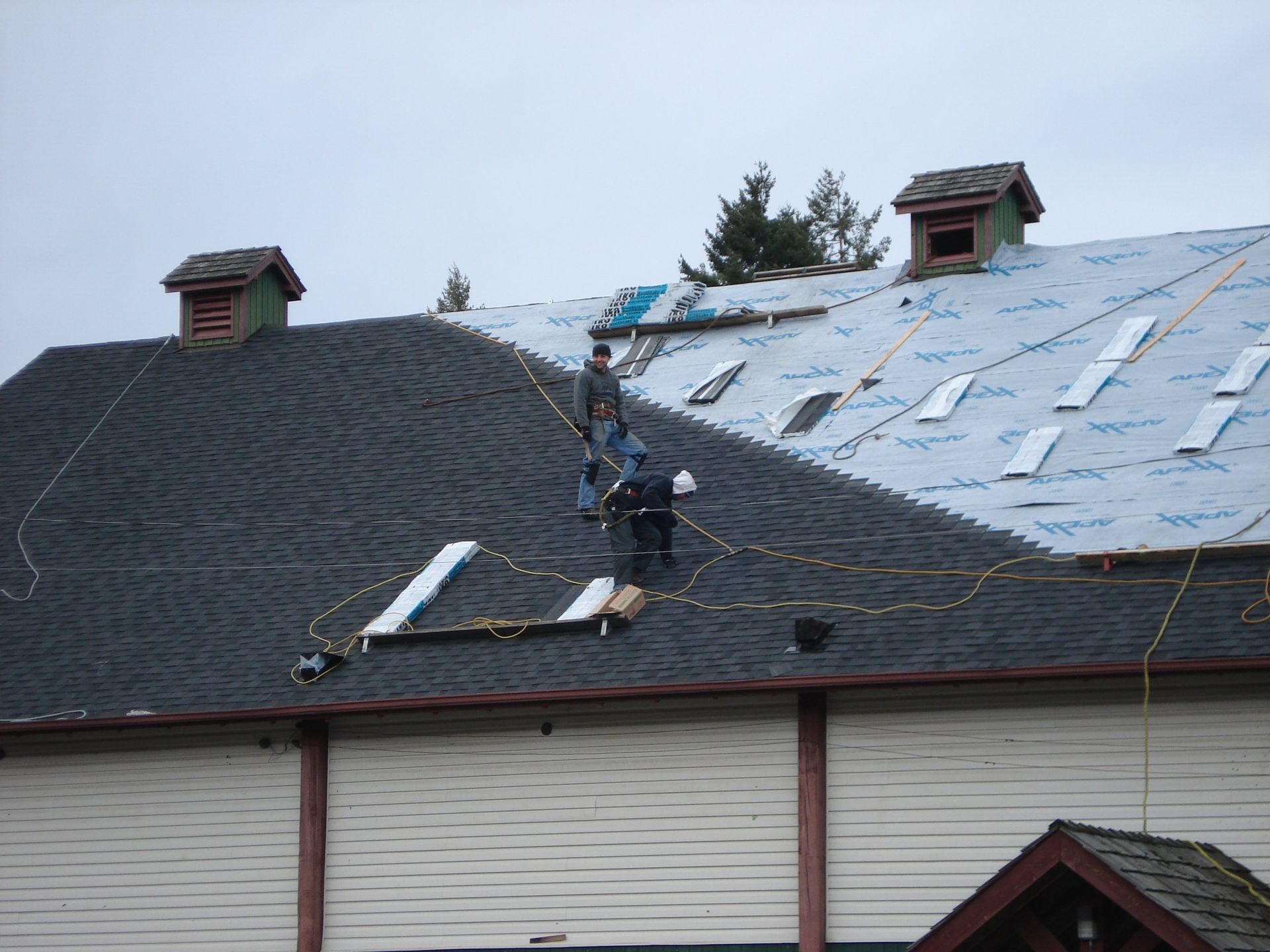 A group of men are working on the roof of a building