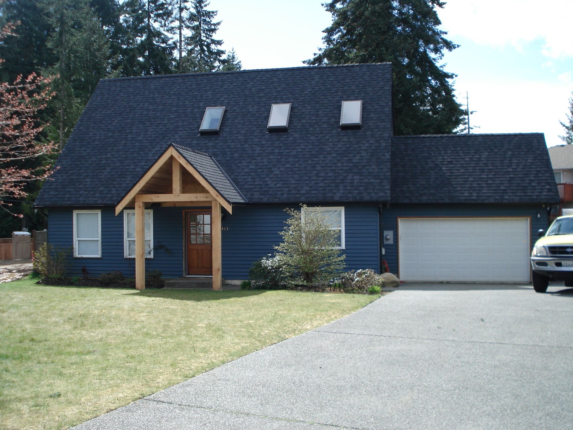 A blue house with a white truck parked in front of it