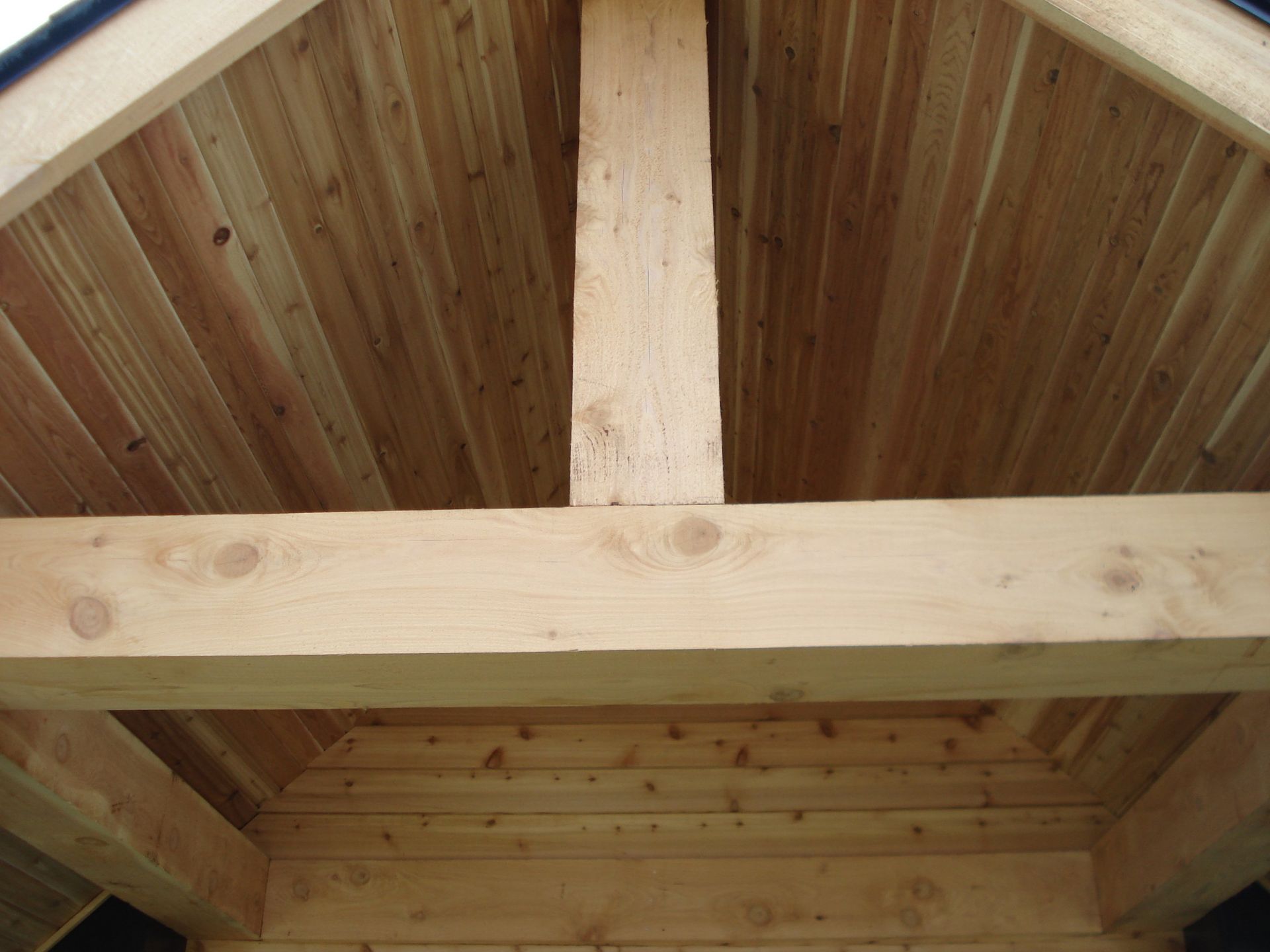 A close up of a wooden ceiling with wooden beams.