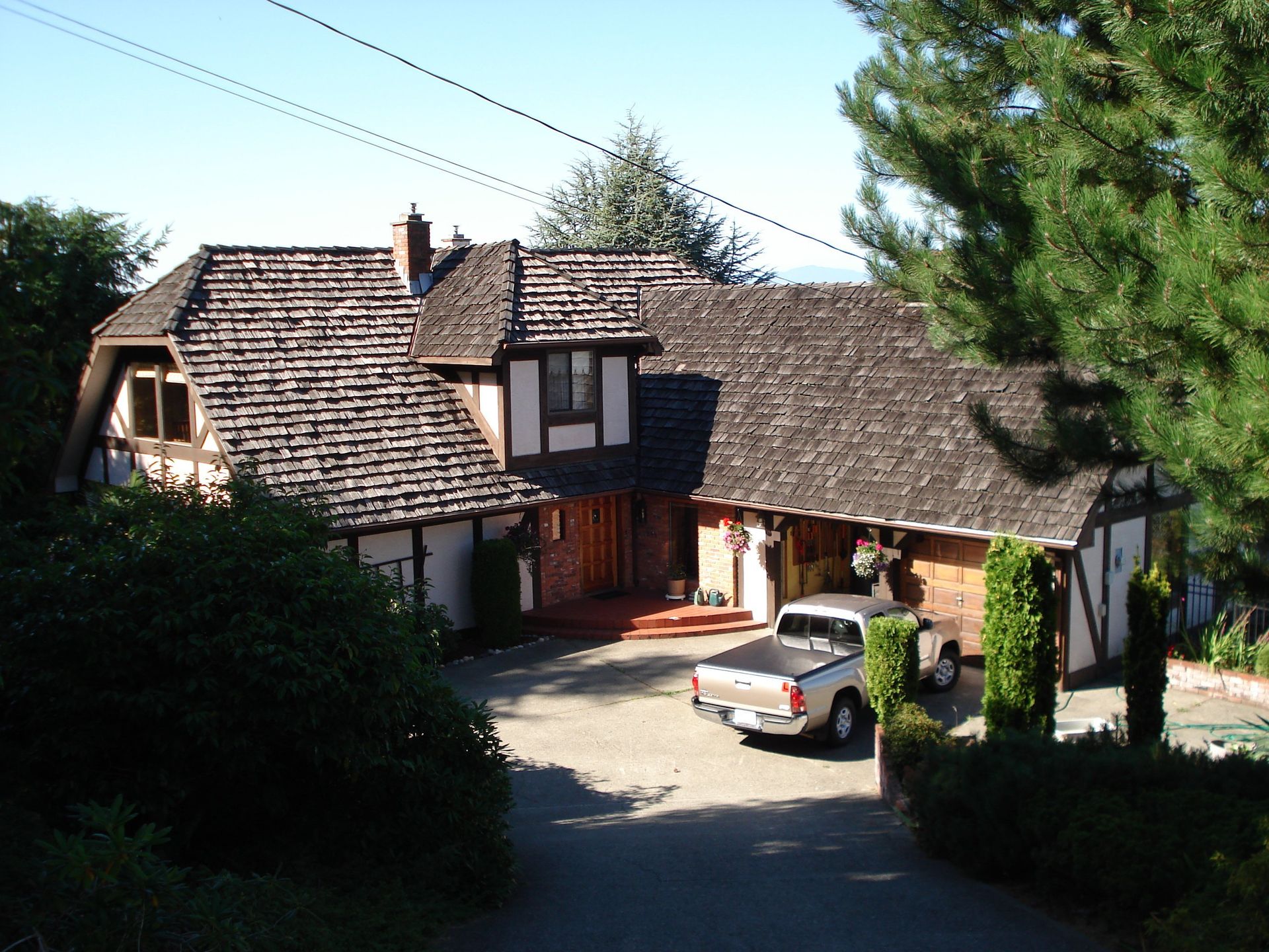 A white truck is parked in front of a large house