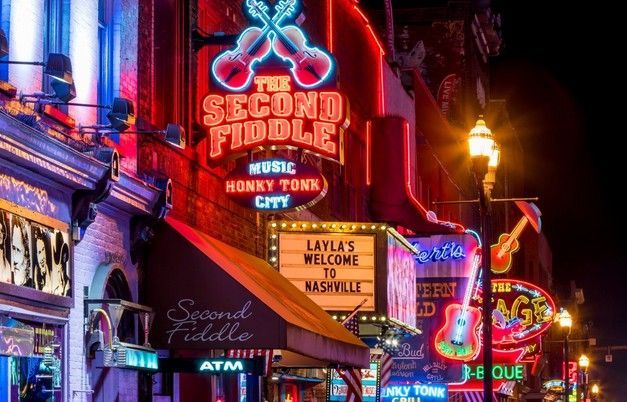 Nashville Broadway honky tonks with neon lights and live country music near Tipsy Tours drop-off