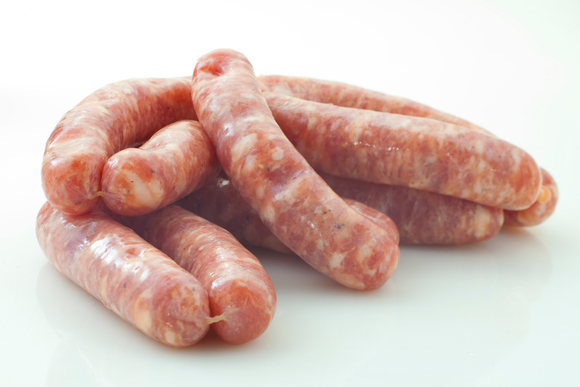 A bunch of sausages are stacked on top of each other on a white surface.