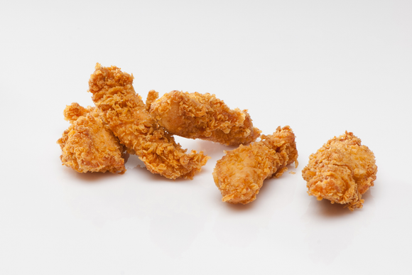 A pile of fried chicken on a white surface.