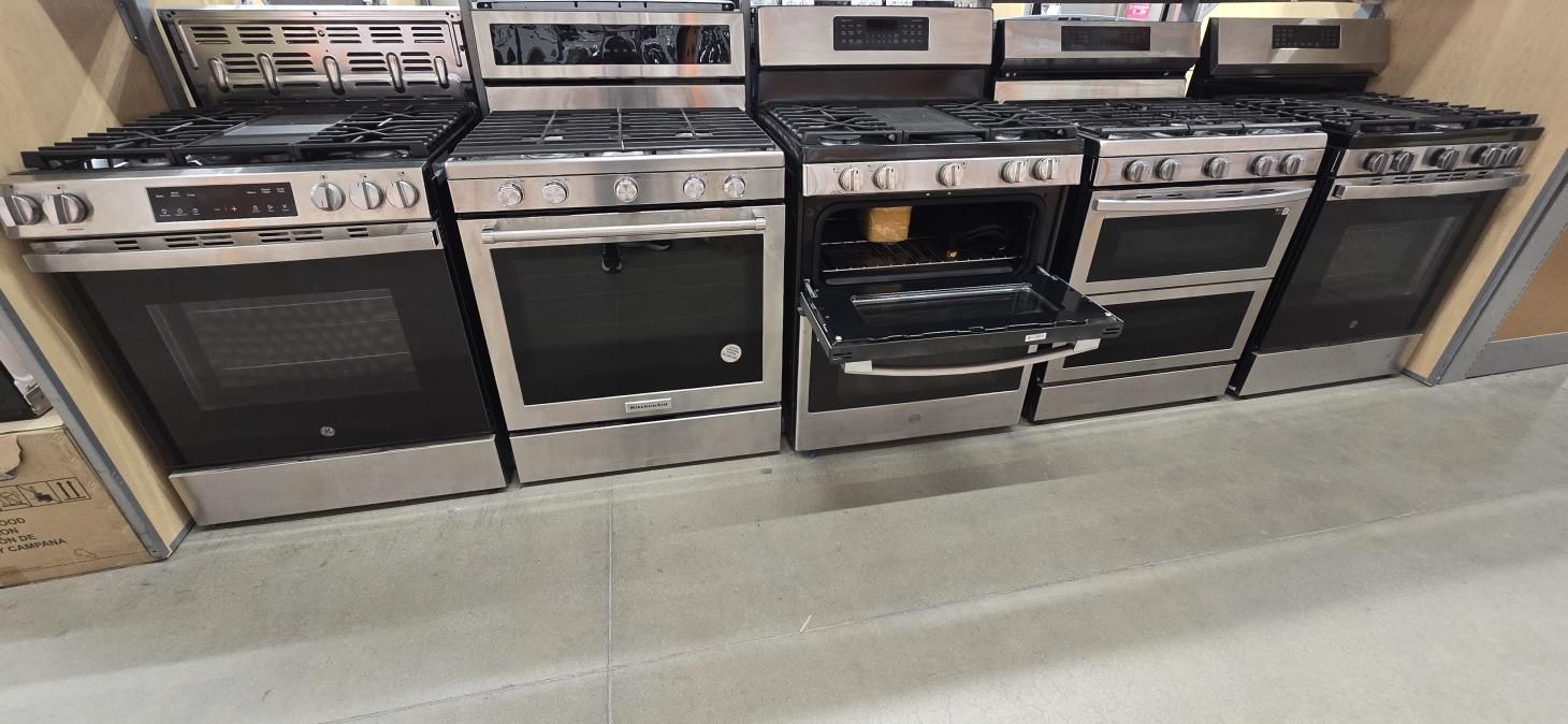 A kitchen with a stove , microwave , sink and dishwasher.