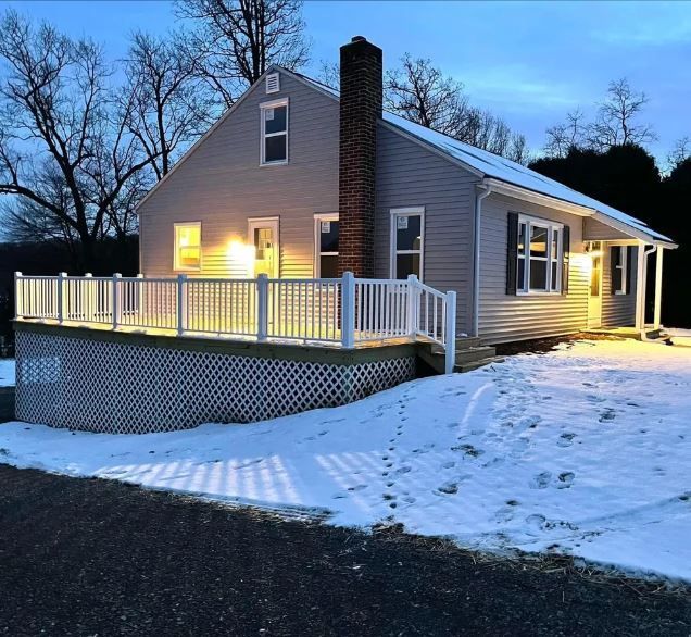 A house with a large deck is lit up at night