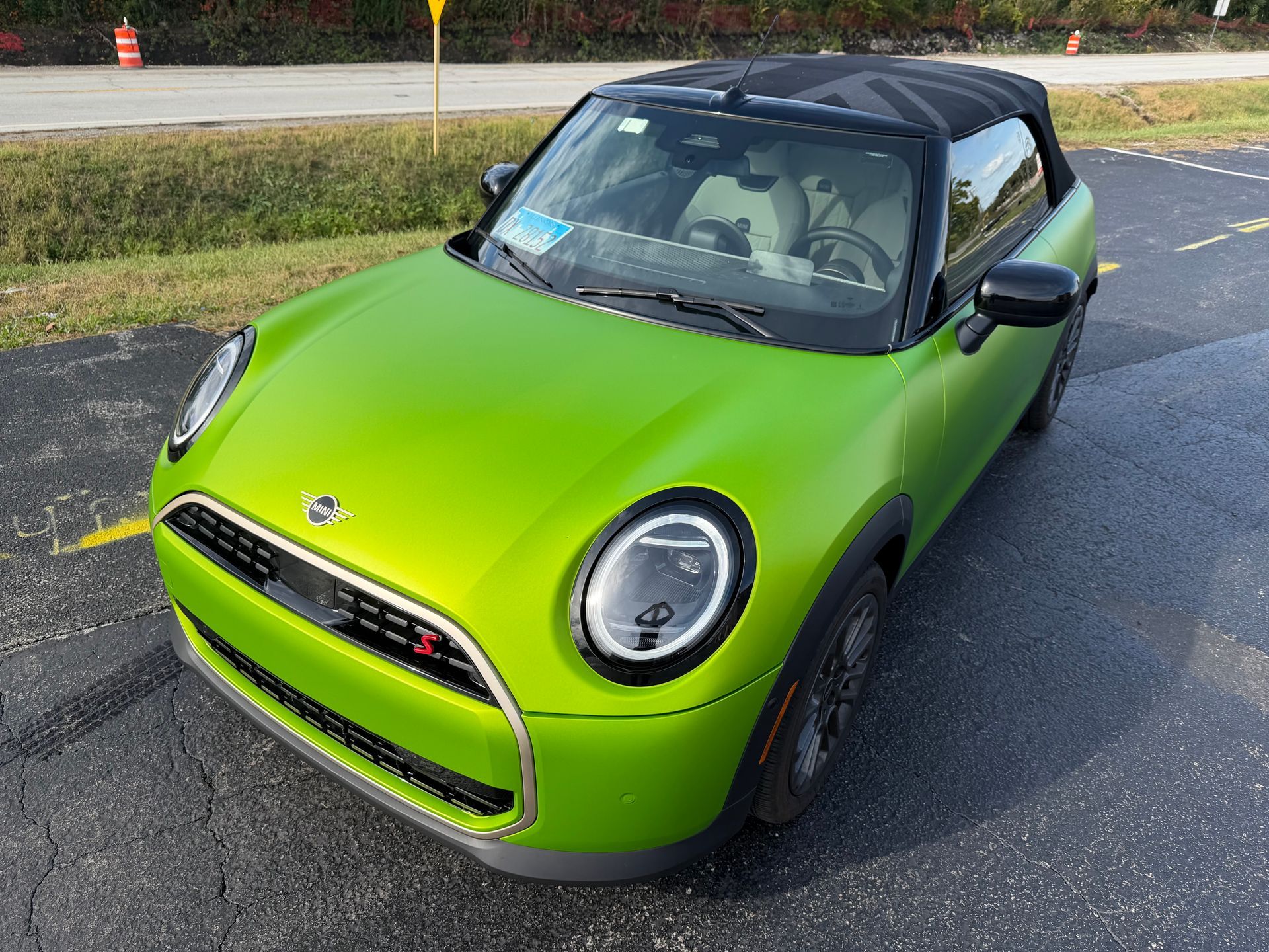 Bright green Mini Cooper convertible parked outdoors.