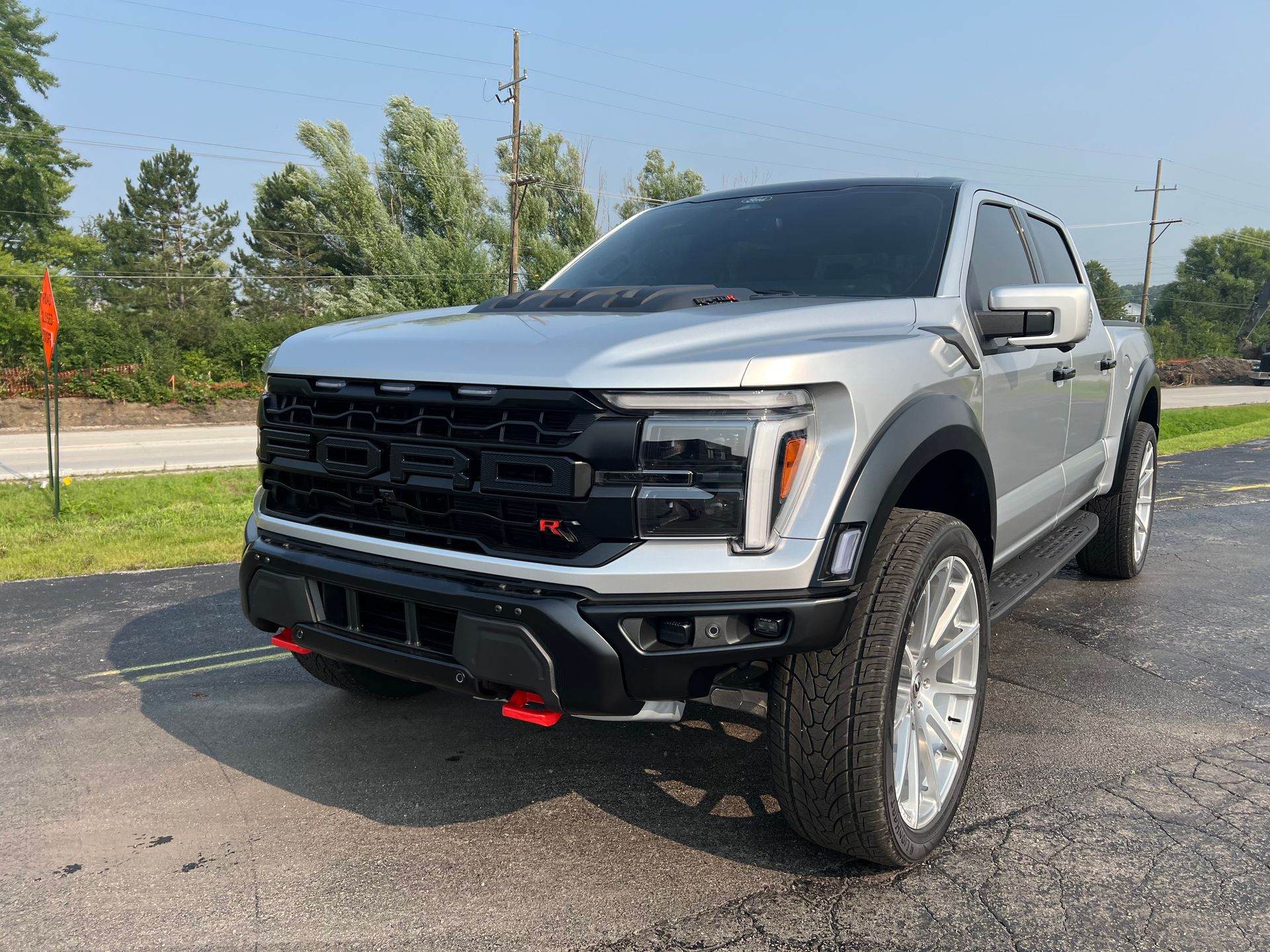 Silver Ford Raptor truck parked on asphalt.