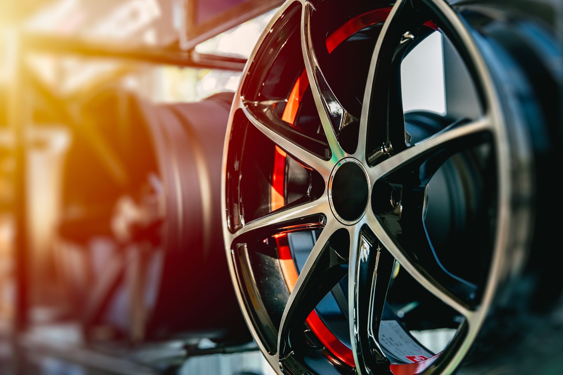 Close-up of a black and silver car alloy wheel with red accents, on display in a store.