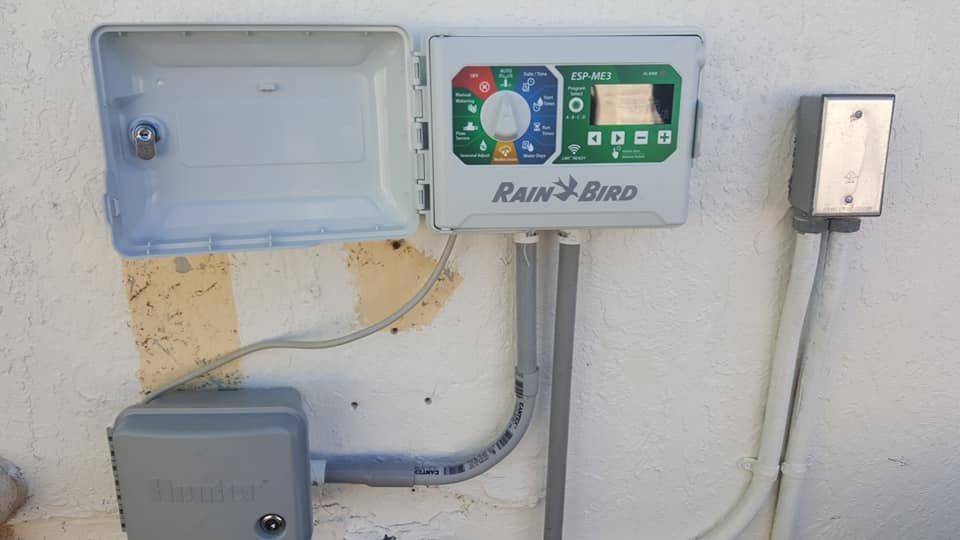 A rainbird irrigation controller is plugged into a wall.