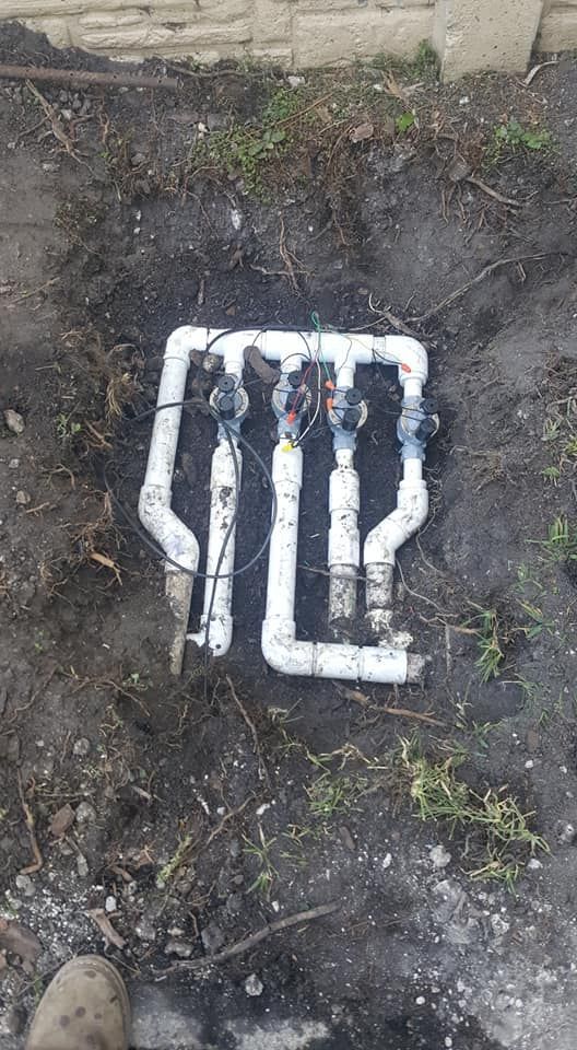 A white pipe is sitting in the dirt on the ground.