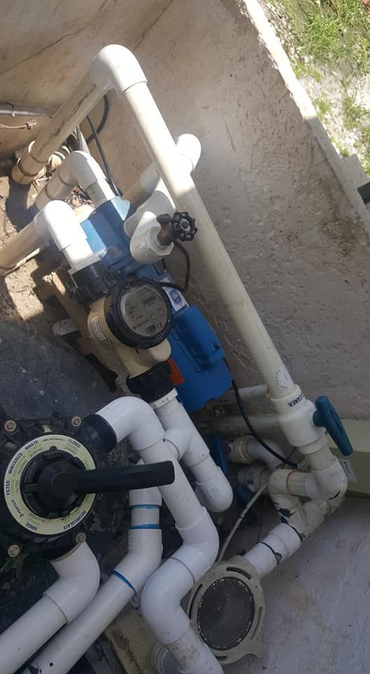 A bunch of pipes are connected to a pool pump.