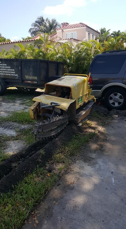 A yellow tractor is parked on the side of the road next to a car.