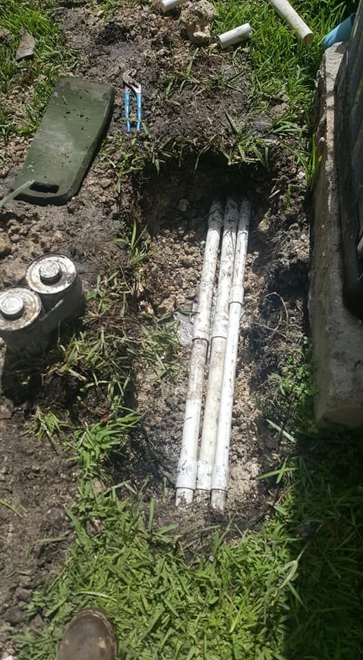 A couple of white pipes are sitting in the dirt.