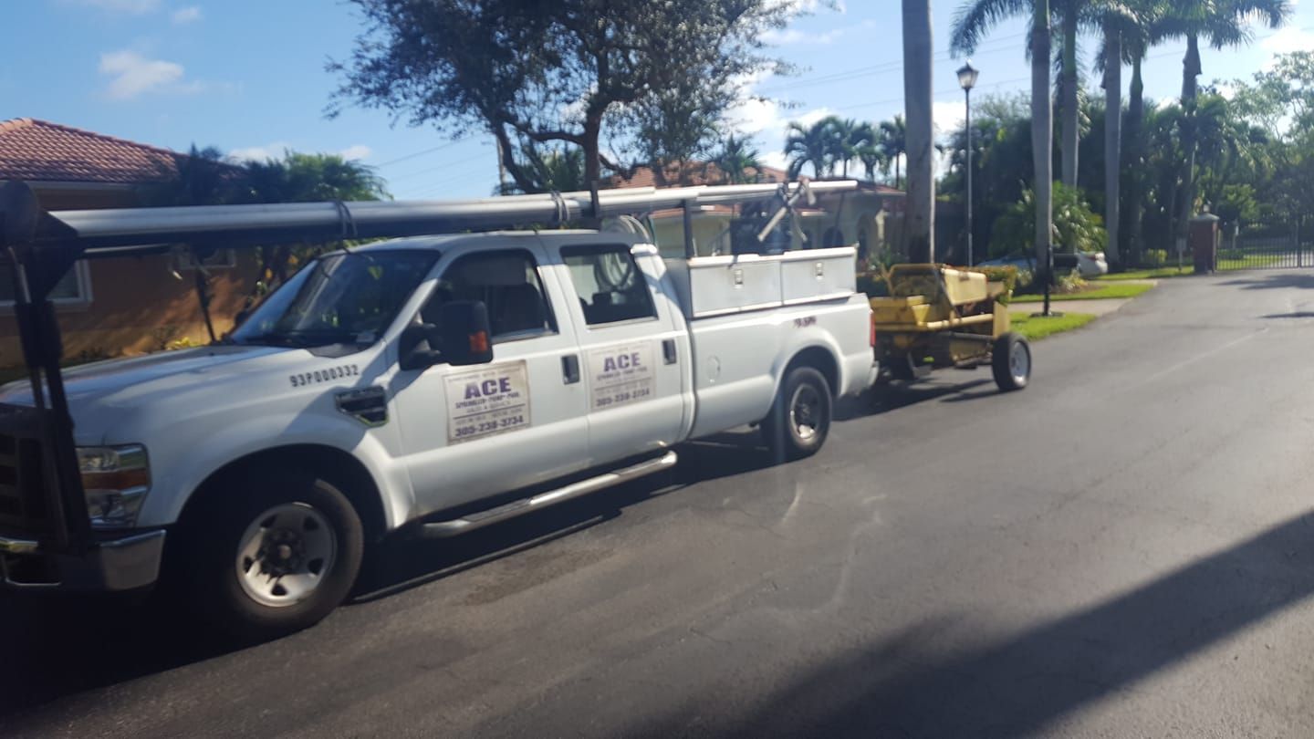 A white truck with a yellow trailer is parked on the side of the road.