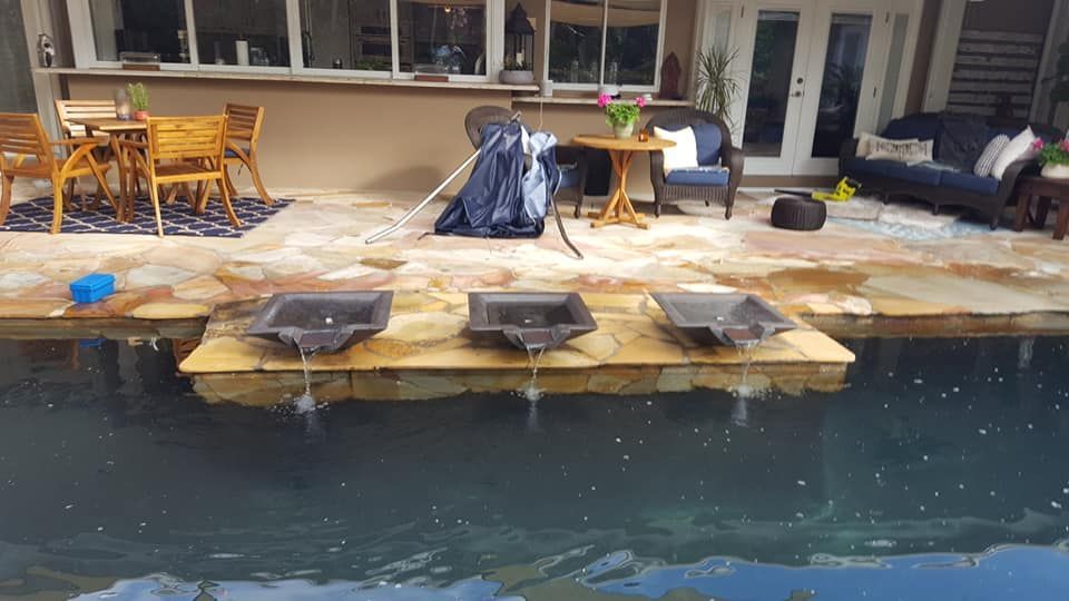 A swimming pool with a table and chairs next to it.