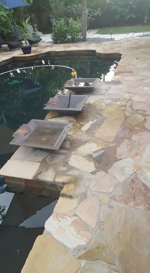 There is a fountain in the middle of the pool.