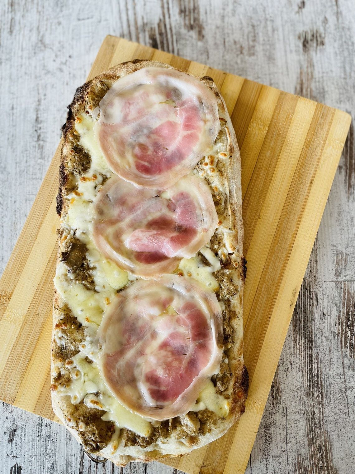 un primo piano di una pizza su un tavolo di legno