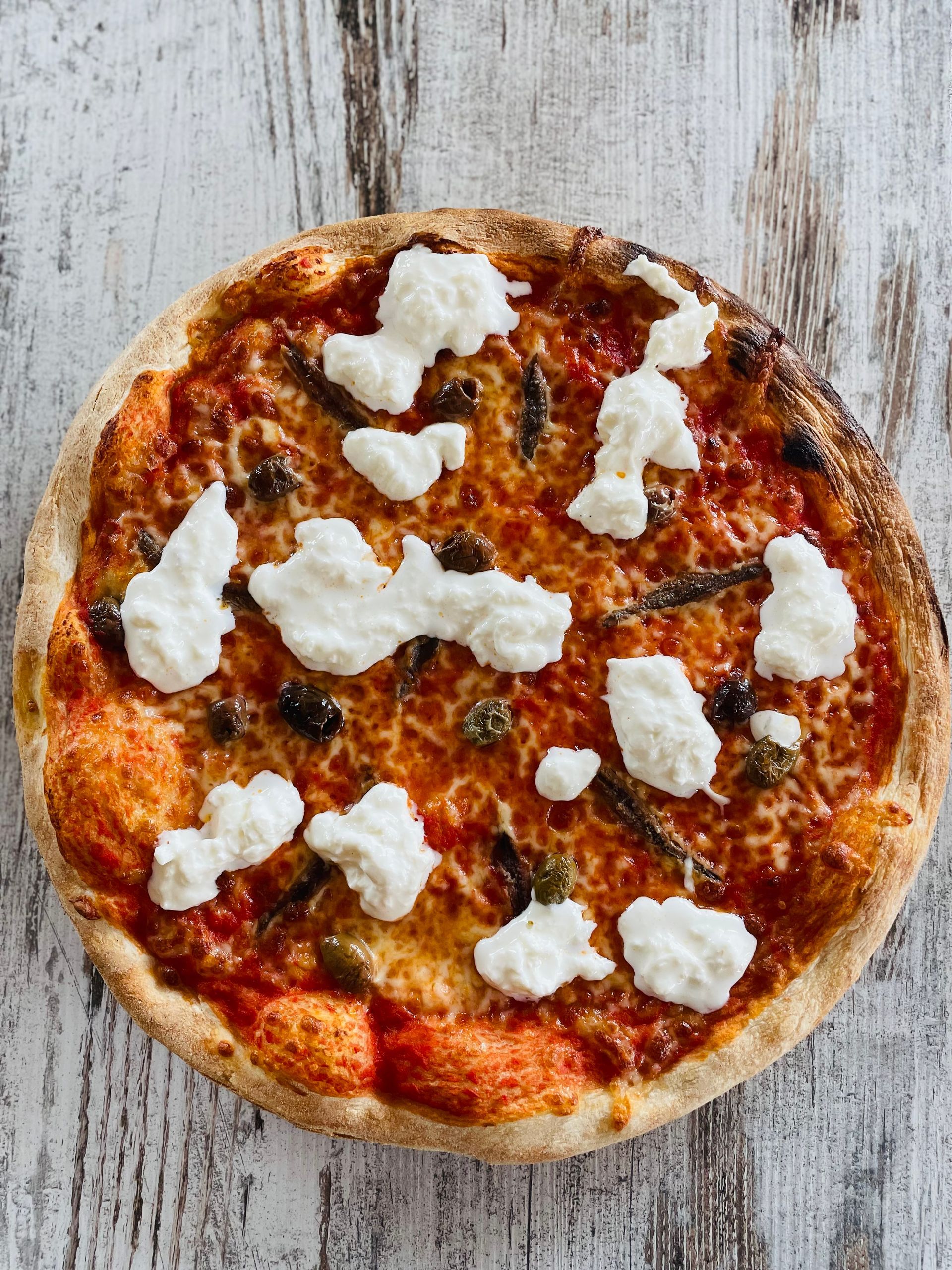 una pizza con melanzane e olive in una scatola