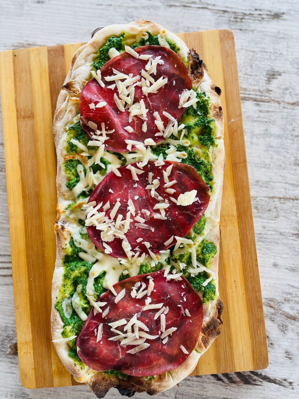 un primo piano di una pizza su un tagliere di legno