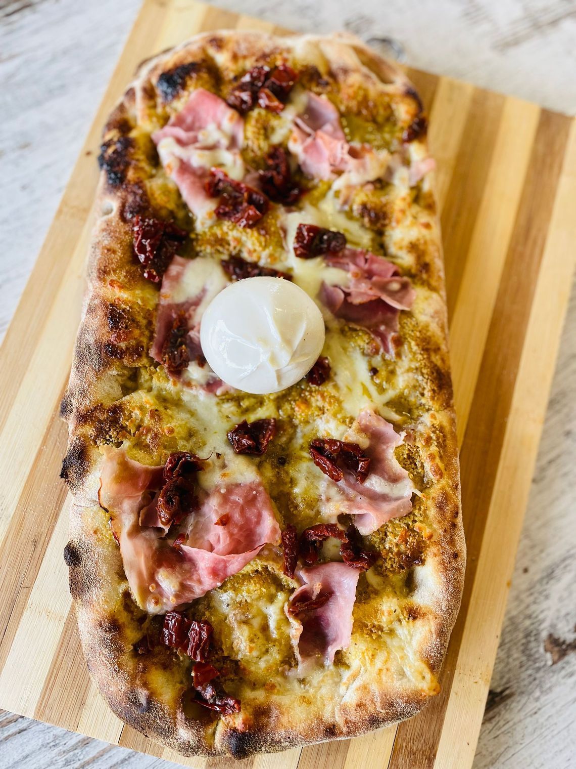 un primo piano di una pizza su un tagliere di legno