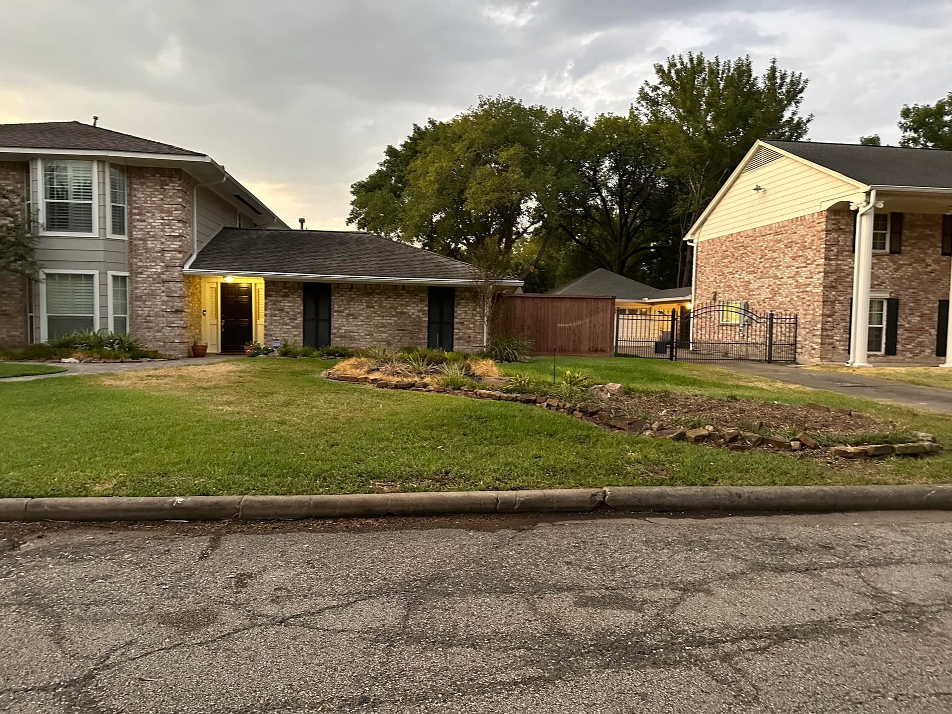 Buildings with brick facades and a grassy lawn under a cloudy sky.
