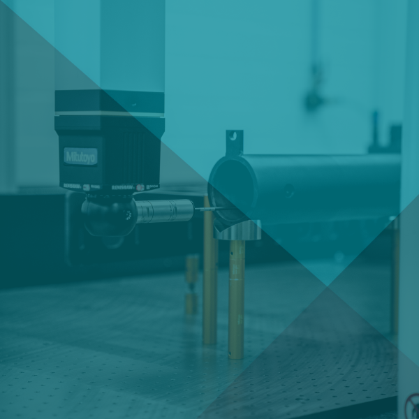 Laborgerät, bestehend aus einem schwarzen zylindrischen Bauteil und goldenen Stützen mit einer türkisfarbenen Überlagerung.