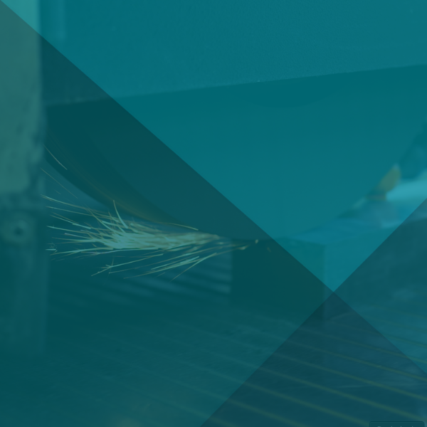 Beim Metallschneiden sprühen Funken. Türkisfarbene geometrische Formen überlagern die Szene.