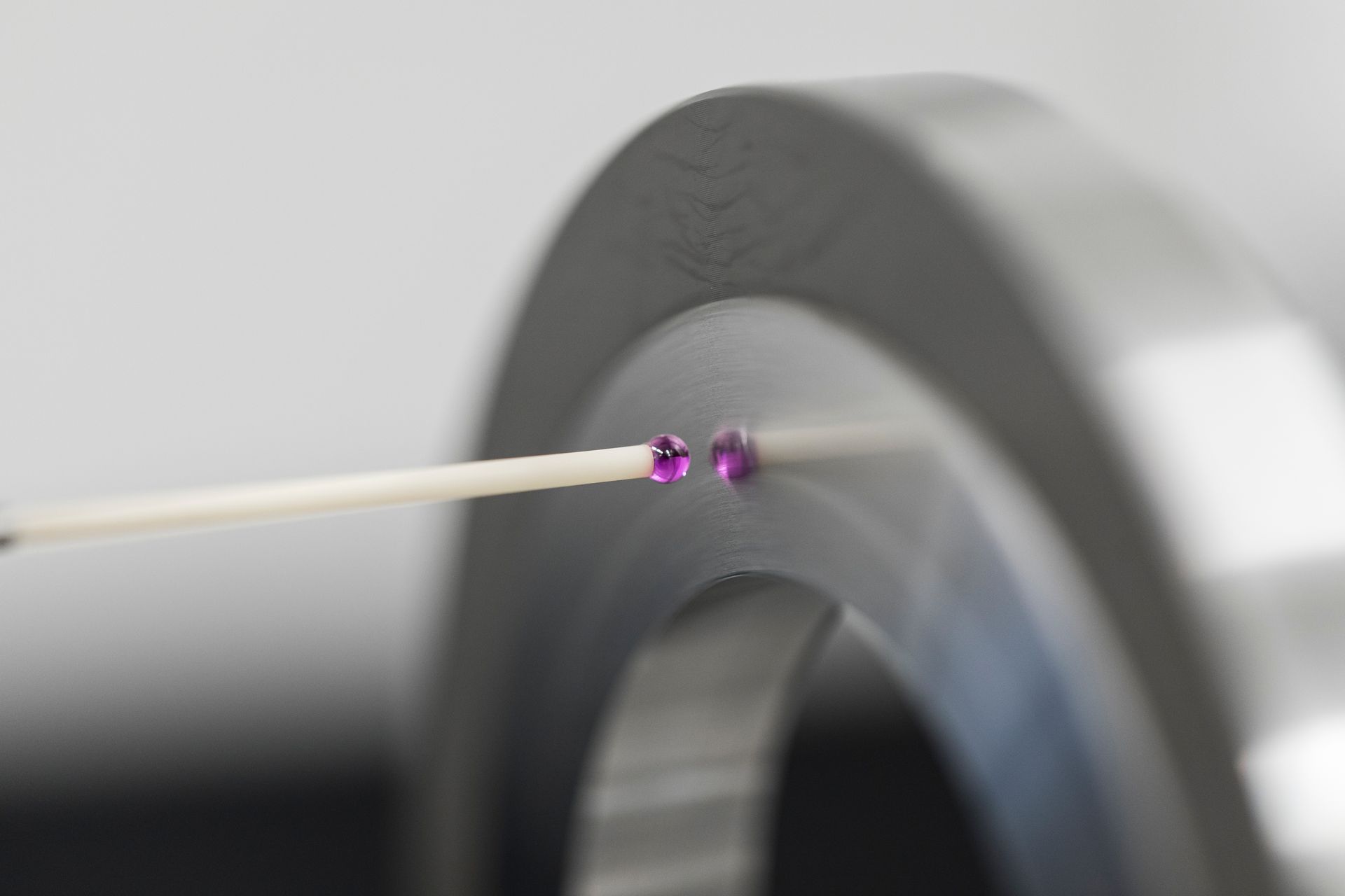 Zur Messung werden zwei Rubinkugeln mithilfe einer weißen Sonde präzise auf einer Metalloberfläche platziert.