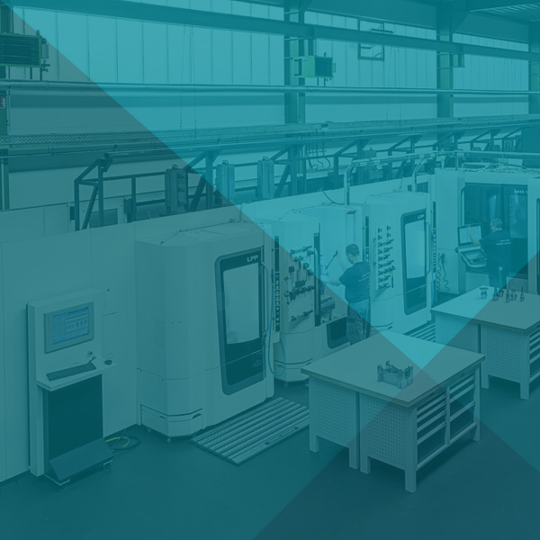 Im Inneren einer Produktionsstätte: CNC-Maschinen und ein Arbeiter.