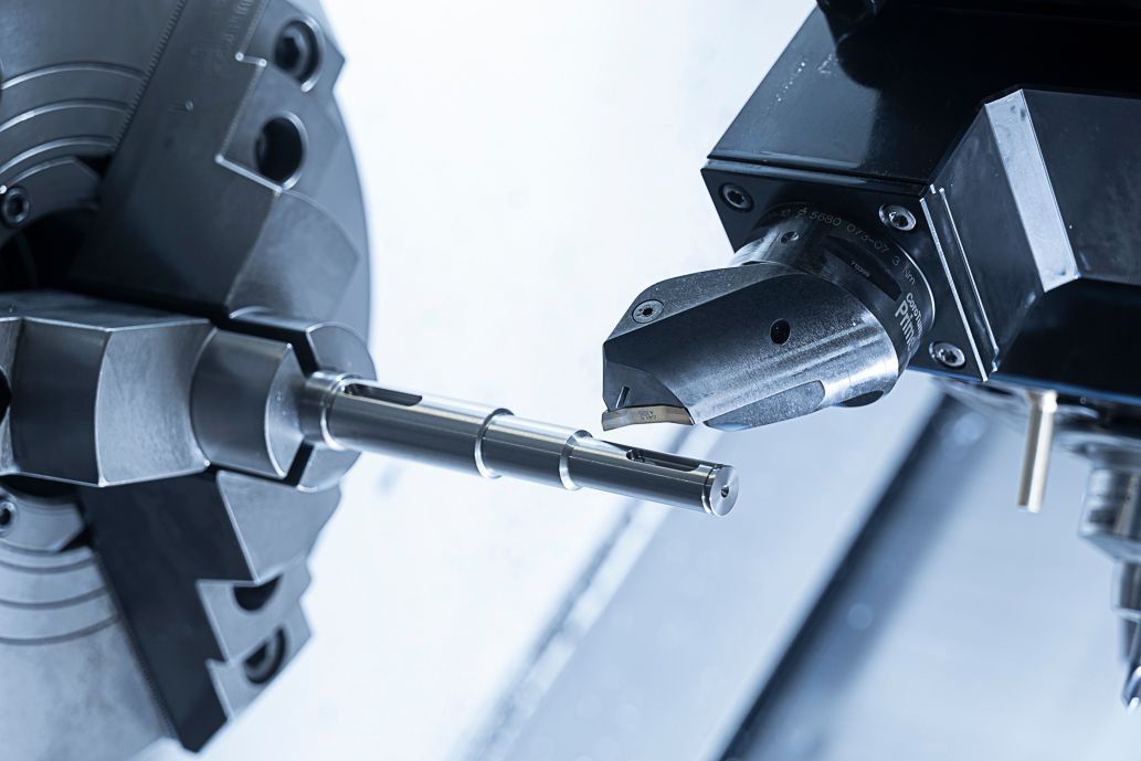 Eine CNC-Maschine schneidet in einer Werkstatt eine Metallstange.