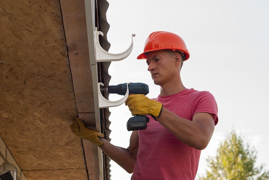 man installing gutter using grinder