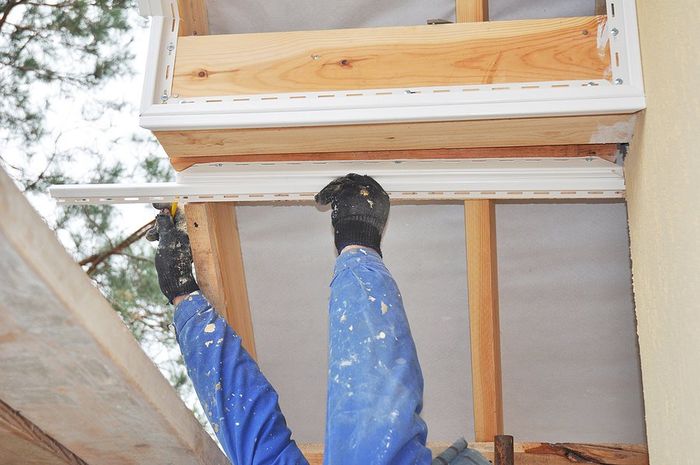 worker repairing the soffit