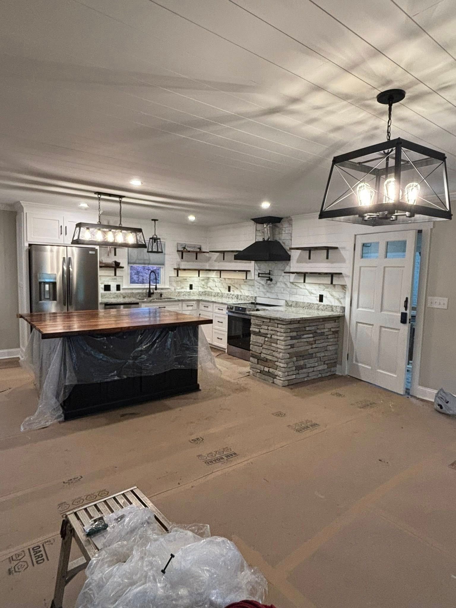 A kitchen with a large island and a chandelier hanging from the ceiling.