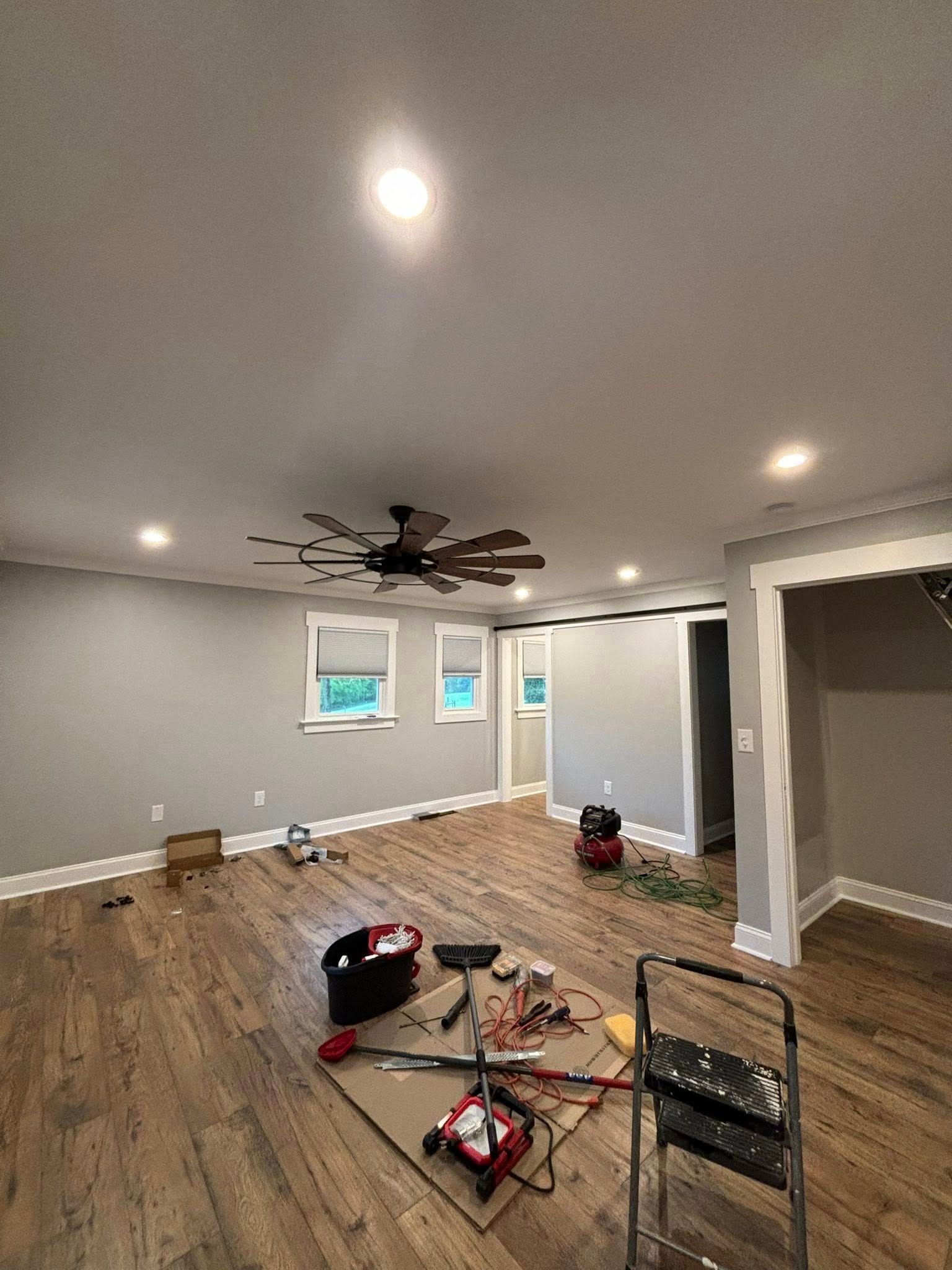 A living room with hardwood floors and a ceiling fan.