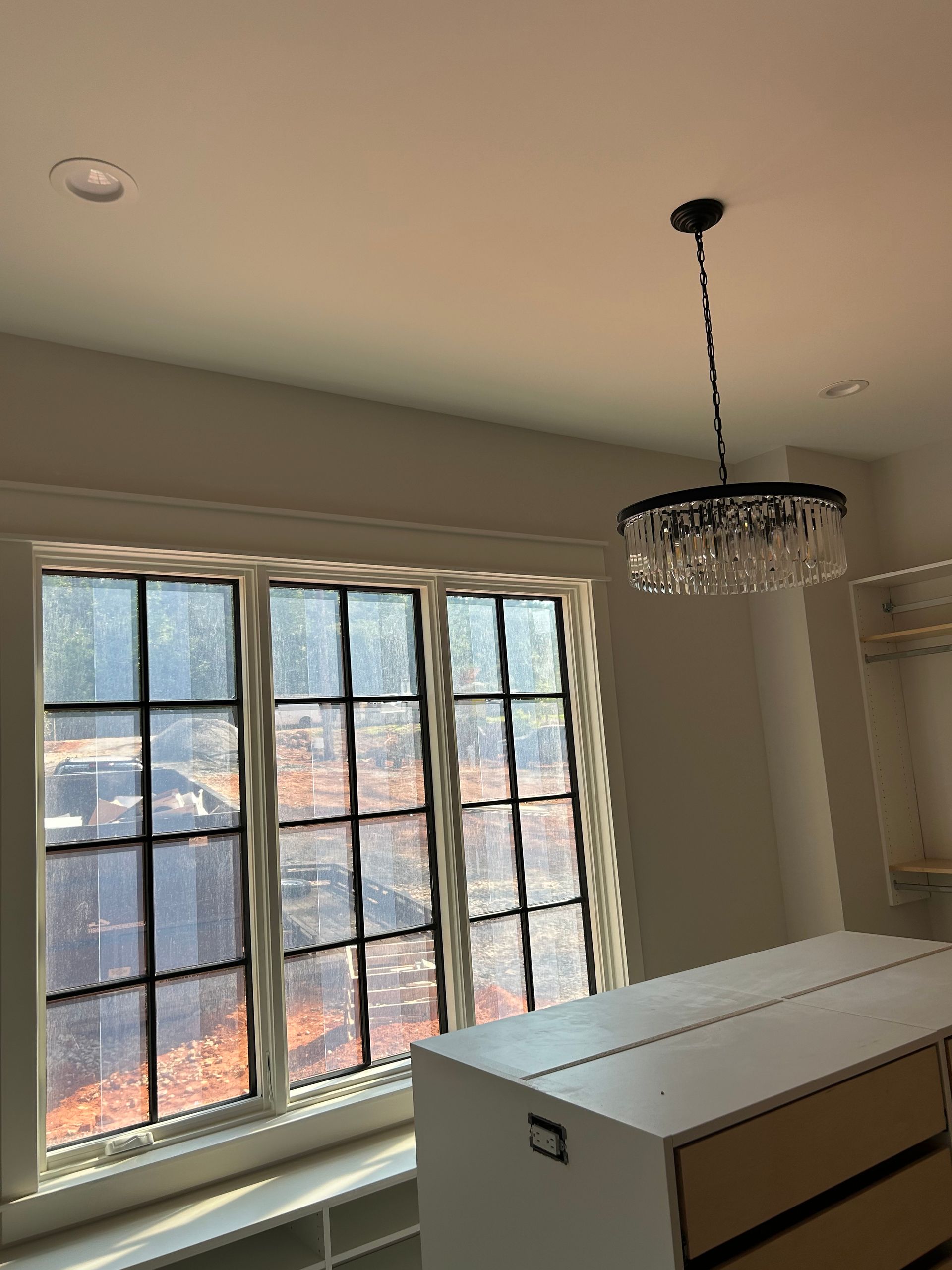 A room with a lot of windows and a chandelier hanging from the ceiling.