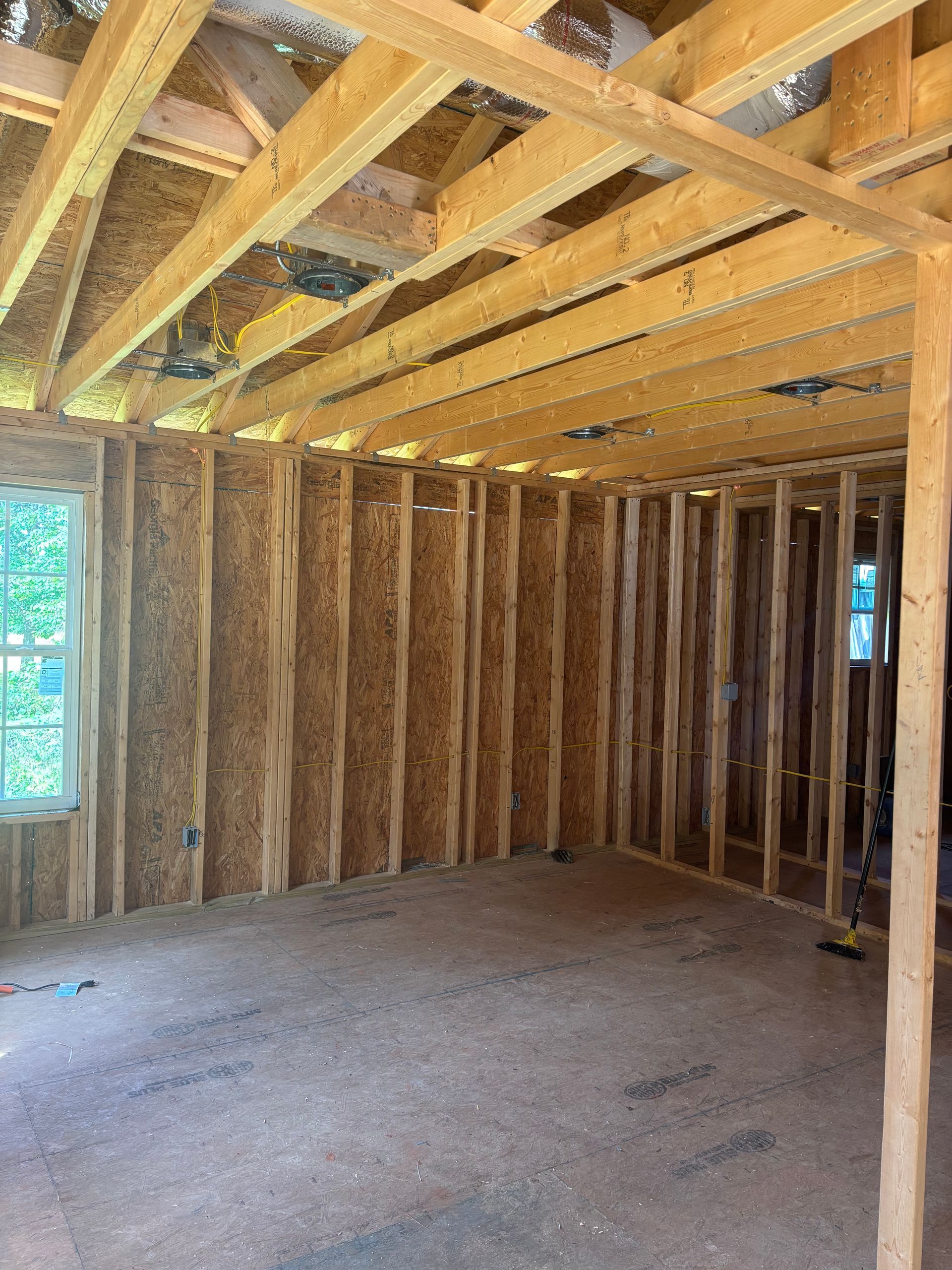 A room under construction with wooden beams and a window.