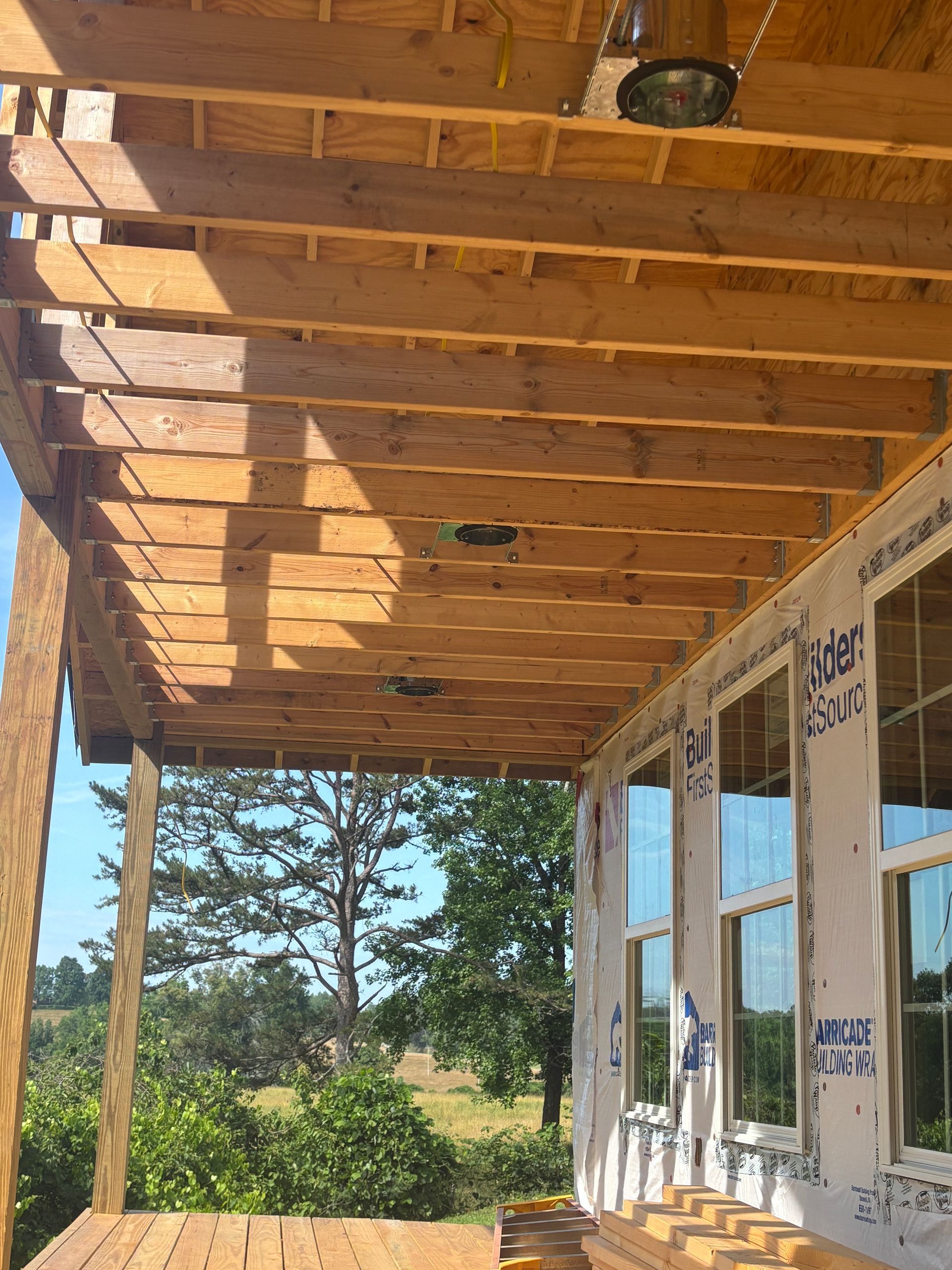 A wooden porch is being built on top of a house.