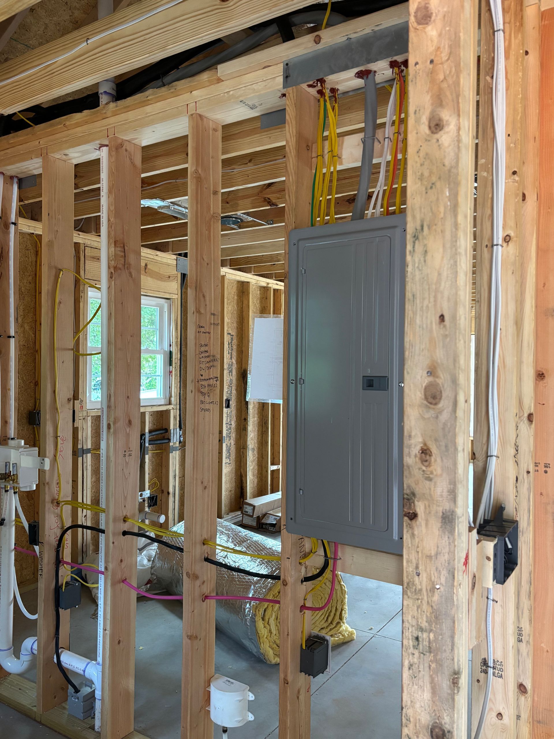 A house is being built with wooden beams and a electrical box.