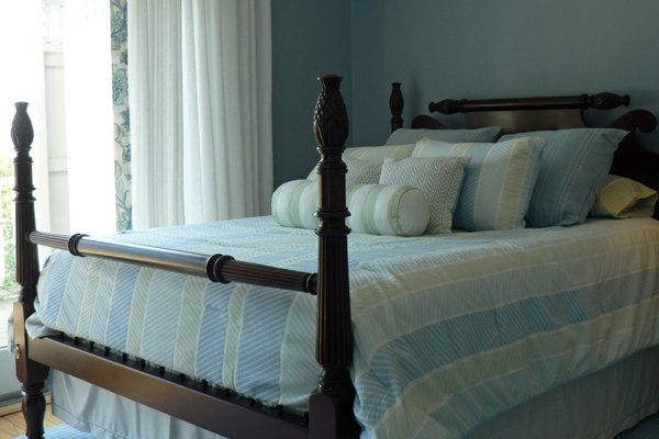 A bed with a blue and white striped comforter and pillows