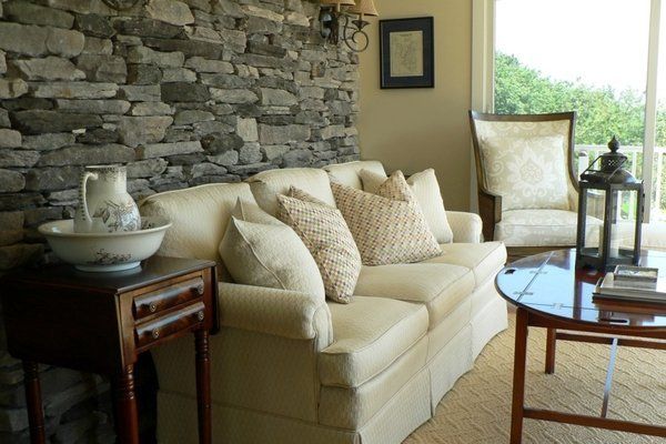 A living room with a stone wall and a white couch