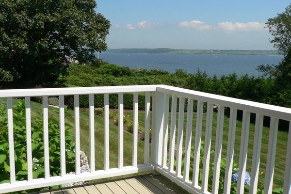 A white railing on a deck overlooking a body of water