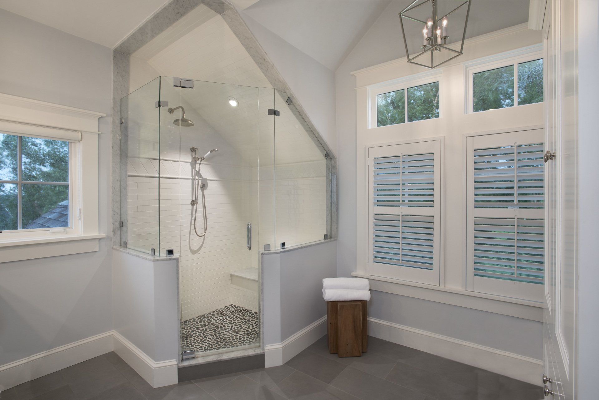A bathroom with a walk in shower and a window.