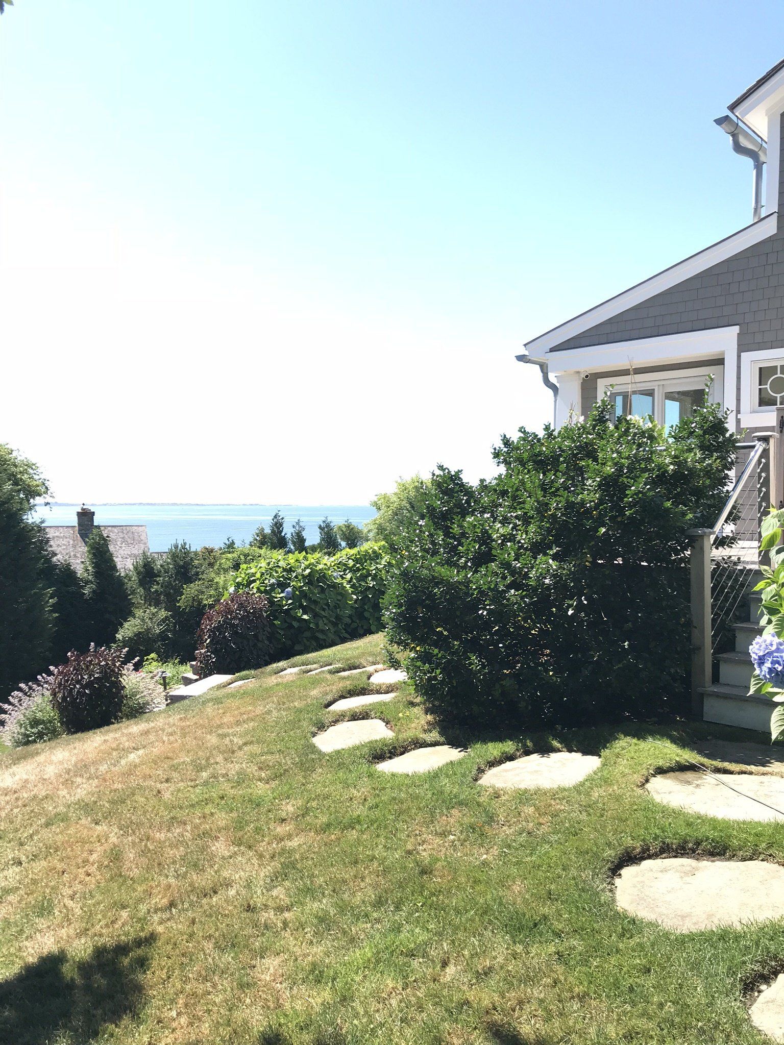 There is a house with a view of the ocean in the background.