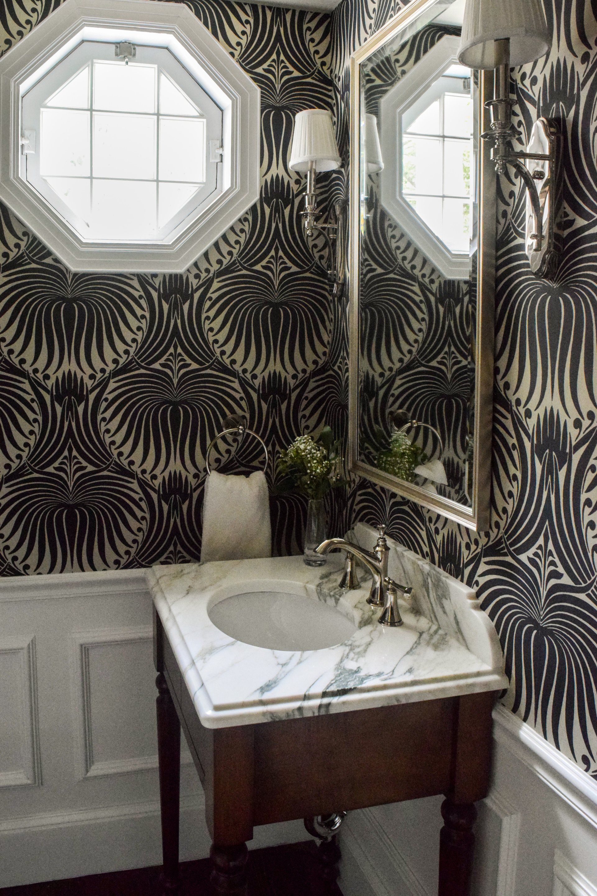 A bathroom with black and white wallpaper and a sink
