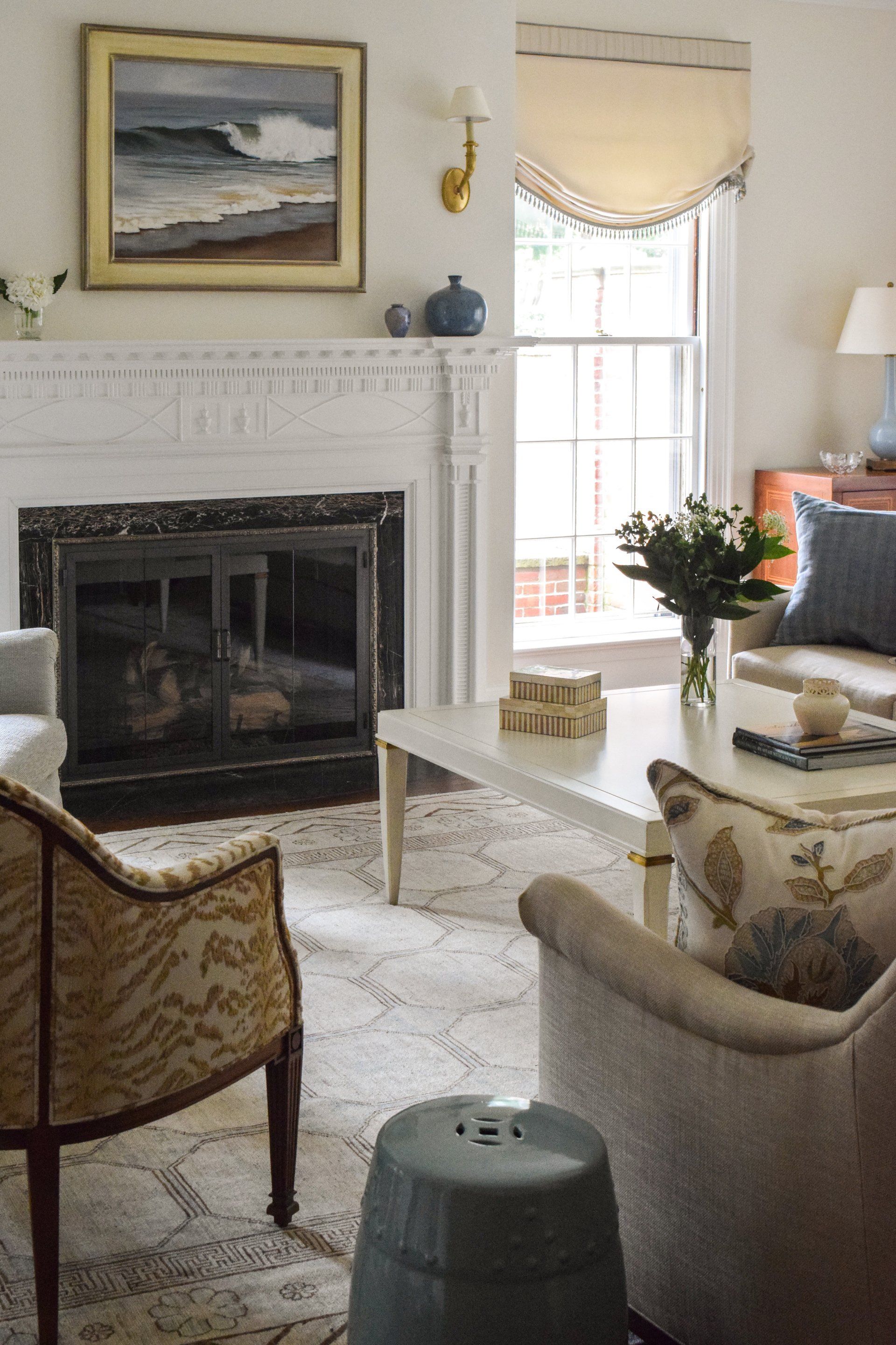 A living room with a fireplace and a painting on the wall